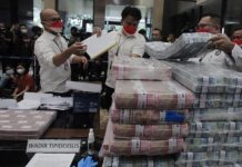 Reserse Kriminal Polri Menyita Uang Sebanyak Rp 217 Miliar dari Jaringan Pinjaman Online FOTO: Petugas menata barang bukti uang tunai kasus pinjaman online (pinjol) ilegal di gedung Bareskrim Polri, Jakarta, Senin, 25 Oktober 2021. ANTARA/Reno Esnir