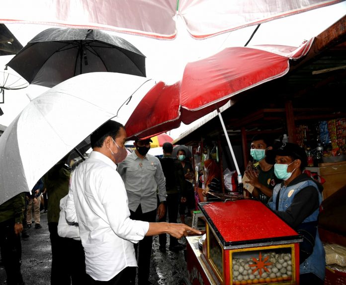 Presiden Jokowi beserta Ibu Negara Iriana Joko Widodo menyerahkan bantuan tunai untuk pedagang kaki lima dan warung di Pasar Kertek, Kabupaten Wonosobo, Provinsi Jawa Tengah, Selasa (14/12/2021). (Foto: BPMI Setpres/Rusman)