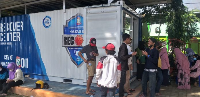 Warga Manuruki saat antri di Kontainer Makassar Recover, yang berada di Taman Man Model Kemenag, Jalan Sultan Alauddin kota Makassar. Jumat, (25/12)