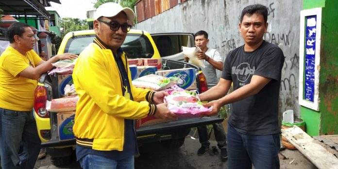 Kiri, Koordinator Wilayah (Korwil) Dapil 1 Makassar DPD II Golkar Makassar, H. Adnan Nizar, saat menyerahkan bantuan kepada korban kebakaran (Malik) di Jl. Muhammad Yamin Baru, RT/RW, 001/005, Kelurahan Barabaraya Timur, Kecamatan Makassar. Rabu, (5/1/2021)