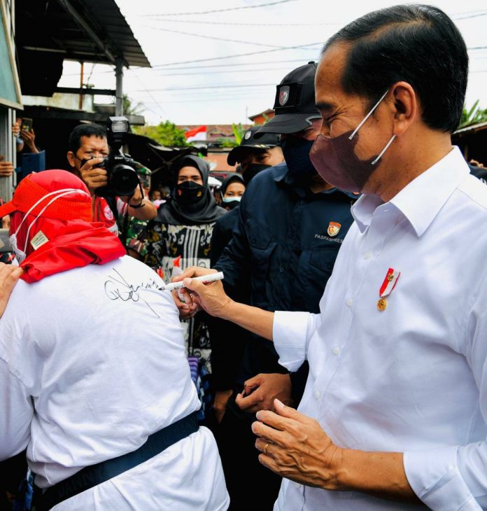 Presiden Jokowi meninjau Pasar Baru Tanjung Enim, di Muara Enim, Sumsel, Senin (24/01/2022). Salah satu pedagang minta dibumbuhi tanda tangan Presiden. (Foto: BPMI Setpres/Laily Rachev)