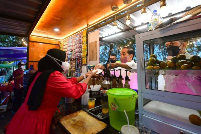 Presiden Jokowi menyerahkan bantuan tunai bagi para pedagang di Taman Batu 10 Kawasan Pasar Bintan Center, Kota Tanjungpinang, Senin (25/01/2022). (Foto: BPMI Setpres/Muchlis Jr)