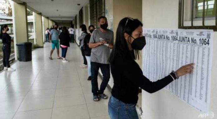 Seorang wanita di San Jose, Kosta Rika melihat daftar untuk menemukan tempat pemungutan suara di mana dia harus memilih saat pemilihan presiden negaranya, kompetisi terbuka yang menampilkan 25 kandidat. (Foto: AFP)