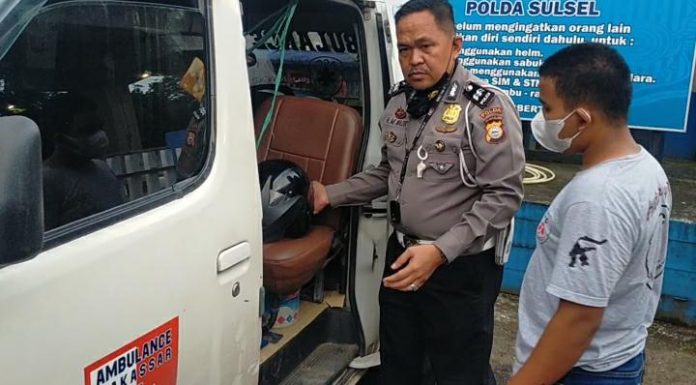 Angota Ditlantas Polda Sulsel Aiptu HM.Nasir, saat menahan mobil ambulance didepan dealer Honda Astra Maros Jl.Poros Maros - Makassar. Kamis, (24/2)