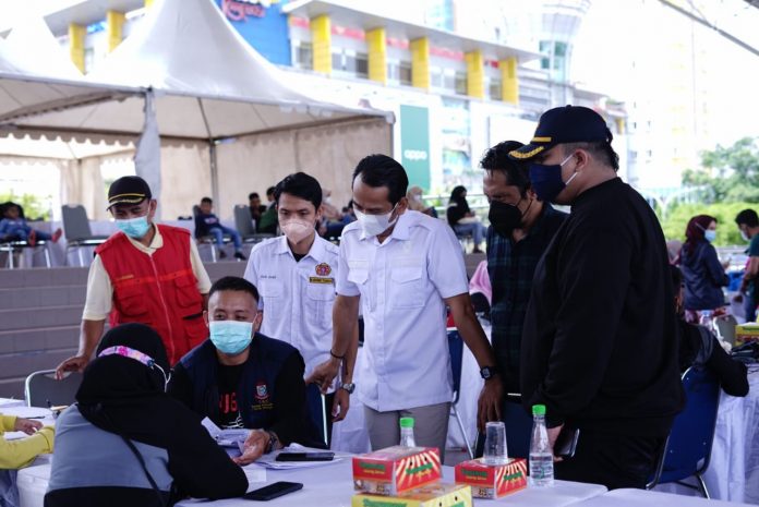 FOTO: Ketua Karang Taruna Sulsel, Harmansyah saat meninjau kegiatan vaksinasi COVID-19 hari ke-2 di tribun lapangan karebosi kota Makassar. Minggu, (27/3)