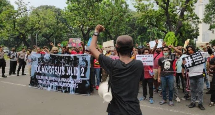 FOTO: Masyarakat dan mahasiswa Papua yang tergabung dalam Komite Aksi Penolakan Otsus menggelar aksi di depan Gedung Kemendagri, Jalan Medan Merdeka, Jakarta Pusat, Selasa (14/7/2020). [Suara.com/Bagaskara Isdiansyah]