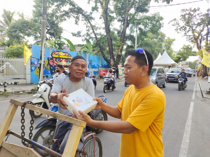 Bendahara DPD II Golkar Makassar saat membagi takjil kepada warga yang melintas di Jl. Lasinrang Makassar. Minggu, (3/4)