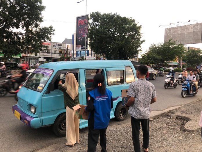 FOTO: Puluhan mahasiswa dari asrama fakfak papua barat turun kejalan berbagi takjil untuk buka puasa bagi masyarakat pengguna jalan di Tamalanrea kota Makassar, Kamis (07/04/2021)