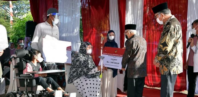 FOTO: Wapres Ma’ruf Amin menyerahkan bansos kepada masyarakat di LRSAMPK Darussa’adah, Aceh Besar, Kamis (14/02/2022). (Foto: BPMI Setwapres)