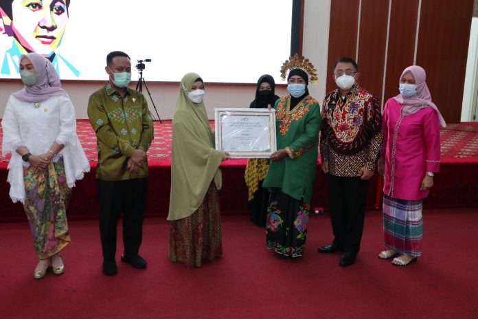 FOTO: Kepala Dinas Pemberdayaan Perempuan dan Perlindungan Anak (DPPPA) Kota Makassar, Achi Soleman saat memberikan penghargaan kepada Nuraeni ketua Shelter