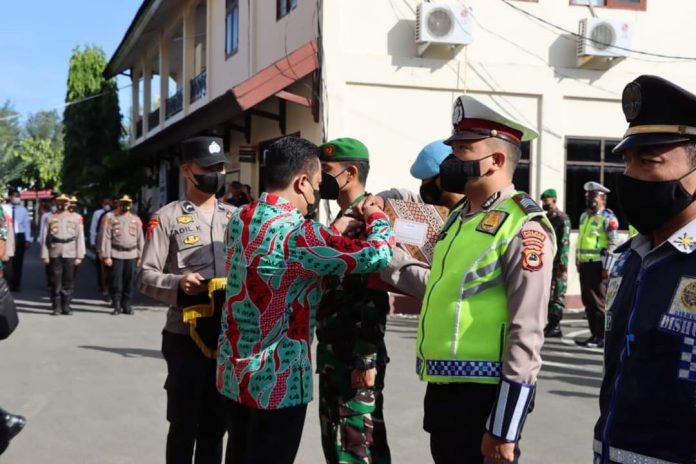 FOTO: Sekretaris Daerah Kabupaten Kepulauan Selayar, Drs. Mesdiyono, M., E.c., Dev, serahkan pita saat Apel besar operasi ketupat digelar di lapangan Apel Mako Polres Selayar, Sulawesi Selatan, hari Jum'at, (22/4)
