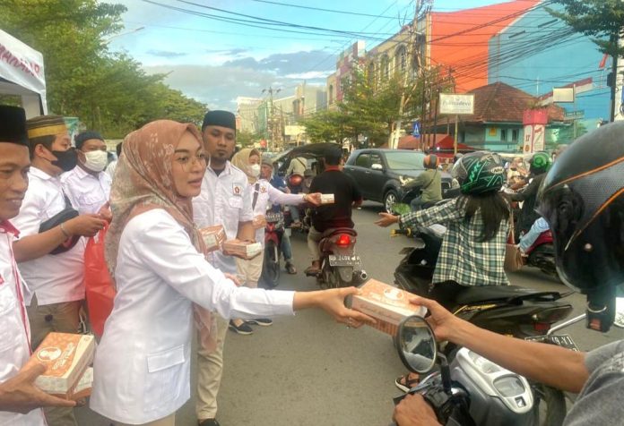 FOTO: Anggota DPRD Kota Makassar, Budi Hastuti saat membagi takjil berbuka puasa di sekitar Jalan Kakatua, Makassar, Kamis (28/4/2022).