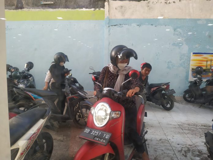 FOTO: Salah satu mahasiswa saat usai berkunjunga perpustakaan wilayah Sulawesi Selatan yang terletak di jalan Sultan Alauddin. Dikenakan bea tarif parkir. Direkam, Senin, (23/5/2022)