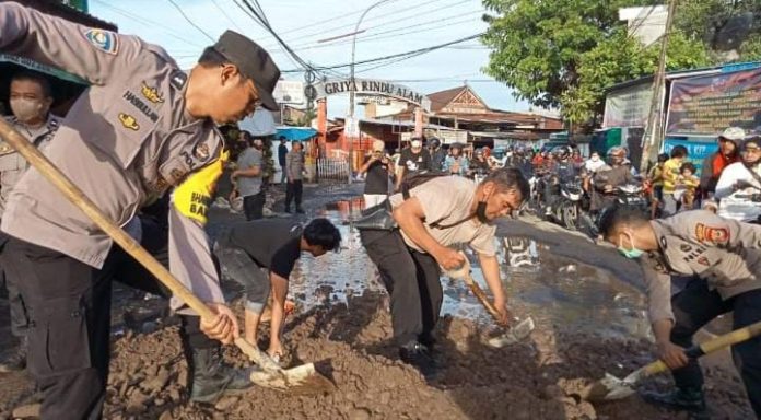 FOTO: Supriadi Idrus, SH berinisiatif menimbun sejumlah lubang menganga yang digenangi air. Senin sore (30/5).