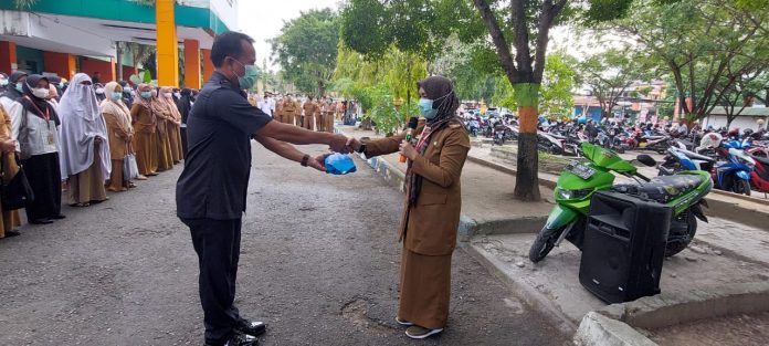 FOTO: Wakil Direktur bidang Pelayanan Non Medik, Pengembangan SDM dan Litbang, Asnarti Said Culla saat memberikan hadiah kepada Madroni. Selasa, (31/5)