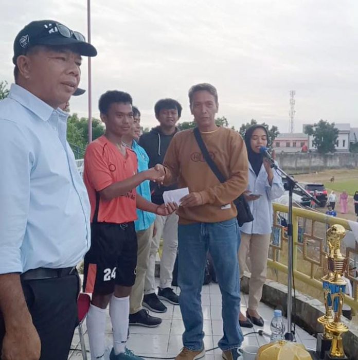 FOTO: Kiri Bupati Bulukumba, saat didampingi Wakil Ketua Pengendali Massa Partai Golkar, Andi Didi menyerah bonus kepada Fahmi. Selasa, (16/8)