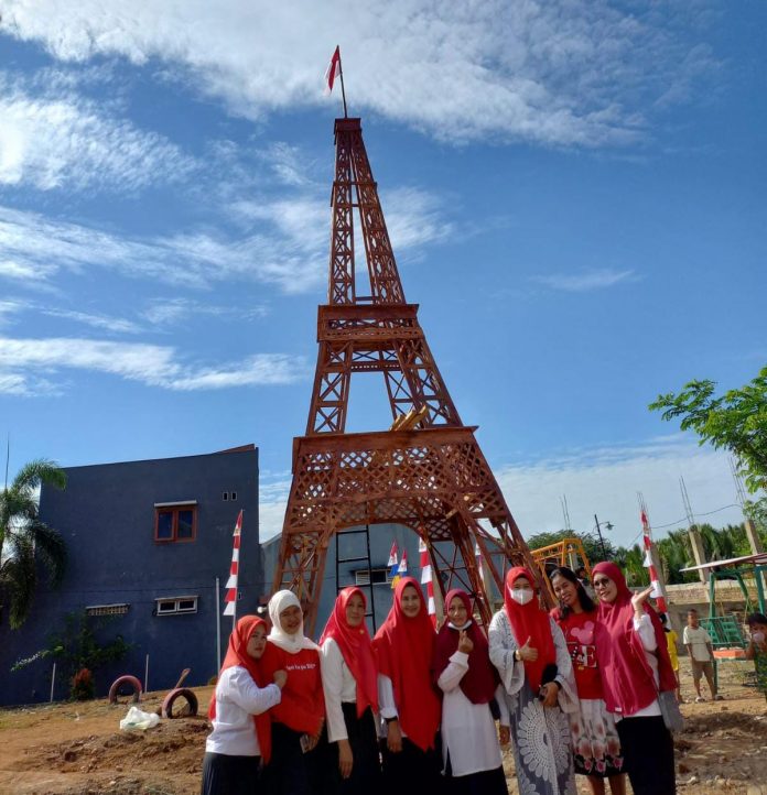 FOTO: Warga Kelurahan Katimbang saat mengabadikan foto berlatar belakang replika menara Eiffel. Rabu, (17/8)