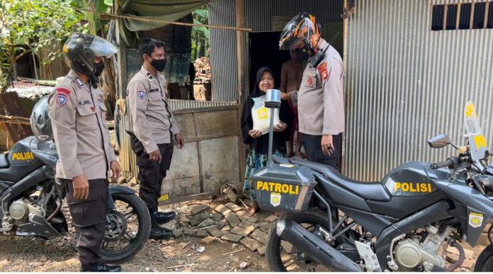 FOTO: Kapolsek dan Babinkamtibmas Turikale saat memberikan bantuan kepada warga kurang mampu di Kelurahan Adatongeng, Kecamatan Turikale, Kabupaten Maros. Kamis (29/9)