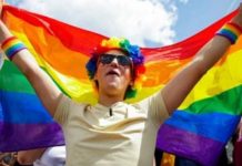 Warga AS Berkumpul di Gedung Putih Rayakan Pengesahan UU Perkawinan Sesama Jenis FOTO: Seorang peserta mengibarkan bendera pelangi selama Parade Kebanggaan LGBT Belgia tahunan di pusat kota Brussel, Belgia, 21 Mei 2022. (REUTERS/Johanna Geron)