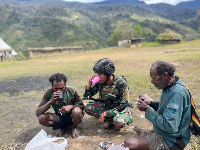 FOTO: Personel Satgas Yonif Raider 321/GT/13/1 Kostrad Pos Kotis Mbua minum kopi bersama warga di Distrik Mbua, Kabupaten Nduga, Papua. Minggu (27/11/22).