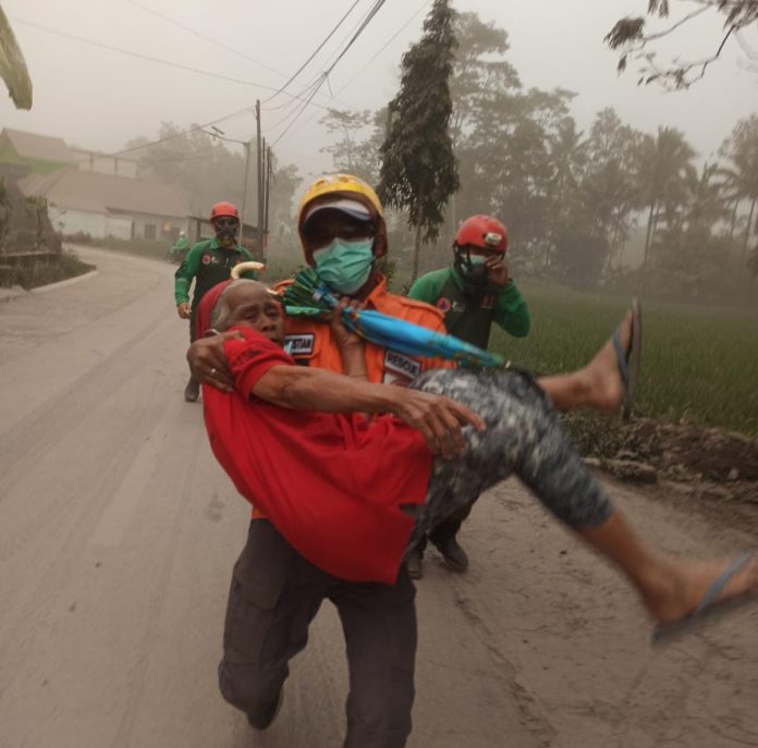 FOTO: Salah satu anggota BNPB saat mengungsikan seorang ibu lanjut usia, (property BNPB)