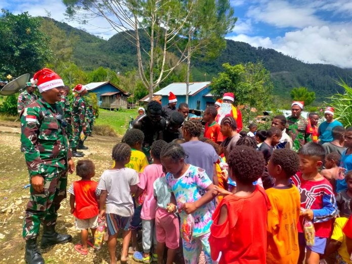 FOTO: Personel Koramil 1715-01/Oksibil dipimpin Kapten Cba Dwi Wawan melaksanakan Pawai Sinterklas sasaran bakti sosial Kampung Kutdol Okpol, Distrik Oksibil, Kab. Pegunungan Bintang, pada Sabtu (17/12/22).