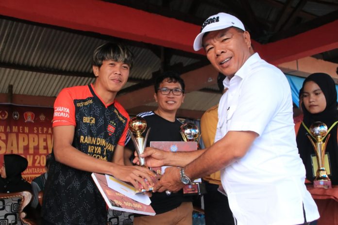 FOTO: Bupati Bulukumba Andi Muchtar Ali Yusuf saat menyerahkan piala ke Sipaenre United pada turnamen sepakbola Andi Sappewali Cup 5 di lapangan sepakbola Desa Dampang, Kecamatan Gantarang, Selasa, 27 Desember 2022. 