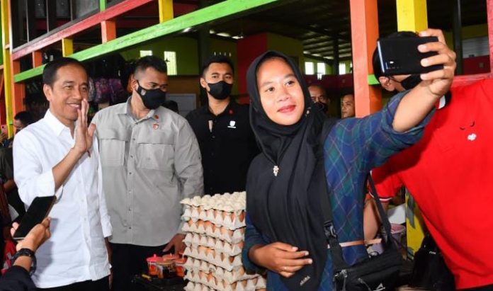 FOTO: Pedagang swa foto bersama Presiden Jokowi saat berkunjung ke Pasar Utan, Kabupaten Sumbawa, Provinsi NTB, pada Kamis (29/12/2022). (Foto: BPMI Setpres/Rusman)