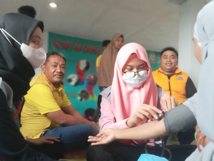 FOTO: Tim Kesehatan DPD II Golkar Makassar memeriksa seorang ibu dan bayi di pengungsian pos yandu anyelir di Blok 8 Perumnas Antang, Kota Makassar. Jumat (30/12/2022)