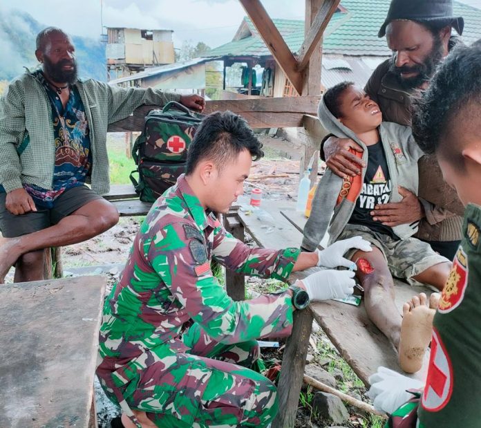 FOTO: Tim Medis dari Pos Dal Satgas Yonif Raider 321/GT/13/1 Kostrad memberikan pertolongan pertama kepada seorang anak yang terkena benda tajam ketika sedang berkebun, bertempat di Distrik Dal, Kabupaten Nduga, Papua.