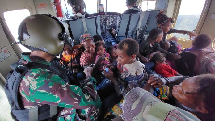 FOTO: Aparat TNI- Polri saat lakukan evakuasi warga beserta anaka-anak Paro, Kabupaten Nduga ke Polres Pelayanan Mimika dengan menggunakan Helikopter, Jumat (10/2/2023).