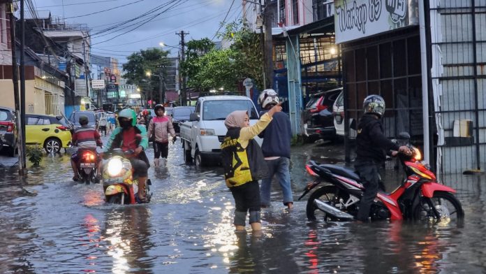 FOTO: Warni Saharuddin, Pimpinan Kecamatan Ujung Pandang Partai Golkar saat mendistribusikan makan siap saji. Senin (13/2)