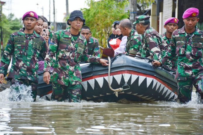 FOTO: Prajurit Petarung Yonmarhanlan VI/Mks laksanakan pembersihan sisa lumpur sekaligus pembenahan jalur irigasi di Komplek Lantamal VI/Mks dan Sekitarnya serta evakuasi tempat tinggal masyarakat yang masih tergenang air. Selasa (14/02/2023).