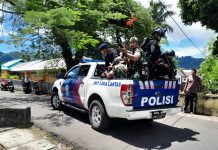 Penuh Dramatis, Polsek Banda Dikepung Ribuan Warga, Pelaku Pemerkosaan Dievakuasi ke Ambon FOTO: Mengunakan Mobil Polantas Anggota Brimob Polri dan TNI saat mengevakuasi pelaku pemerkosaan ke bandara Banda Naira. Jumat (24/3)
