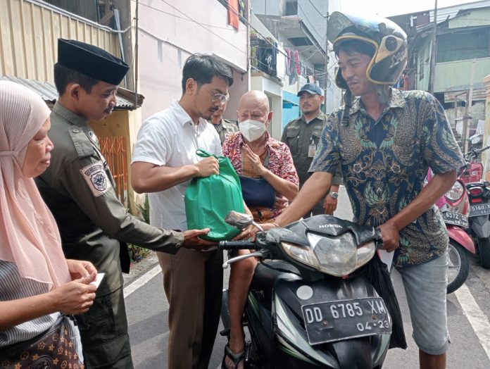 FOTO: Ketua Forum Kemanusian Kota Makassar (FKKM), dr Udin Malik bersama Golorong Indonesia berbagi 135 paket sembako, Senin (17/04).