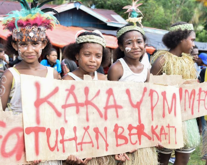 FOTO: Pelajar di Distrik Yapen Barat Ansus Kabupaten Kepulauan Yapen saat menyambut kedatangan Anggota Komisi I DPR RI Yan Permenas Mandenas. Senin, (08/05/2023).