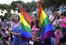 Jangan Rendahkan LGBTQ di Singapura FOTO: Siswa Ashleigh Ng, 15, menari mengenakan bendera pelangi, selama pertunjukan konser di sebuah taman untuk acara kebanggaan gay tahunan Pink Dot pada hari Sabtu, 1 Juli 2017, di Singapura. (properti the diplomat)