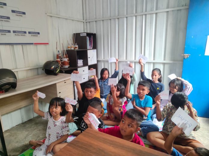 FOTO: Anak putusan sekolah saat sedang belajar membaca disalah satu perpustakaan Lorong di Kelurahan Panampu, RW. 03, Kecamatan Tallo, Makassar.