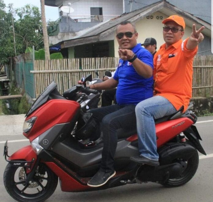 FOTO: Syamsir Saeni alias Anchy eks Ketua RW 01, Keluarkan Pandang saat berkendaraan motor roda dua bersama Moh. Ramadhan Pomanto atau 'Danny Pomanto' saat menuju lokasi kampanye pemilihan wali kota Makassar.