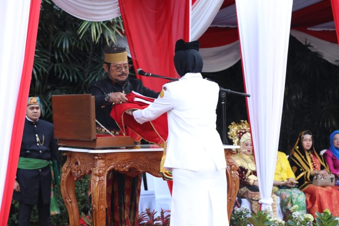 FOTO: Menteri Pertanian (Mentan) Syahrul Yasin Limpo saat menyerahkan bendera merah putih kepada petugas penaikan bendera pada Upacara HUT Kemerdekaan RI ke-78 di kantor pusat Kementan, Jakarta, pada Kamis, 17 Agustus 2023.