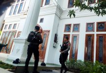 Penyidik KPK Boyong Sebuah Koper dan Sita 1 Unit Mobil Mewah dari Kediaman Mentan di Makassar FOTO: Dua personel kepolisian berjaga-jaga di halaman depan pintu teras rumah Menteri Syahrul Yasin Limpo di Perumahan Bumi Permata Hijau (BPH) Blok C No. 1, Jalan Sultan Alauddin, Kecamatan Rappocini, Makassar, Sulawesi Selatan, Rabu (4/10/2023). (Foto:Antara)