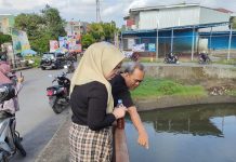 Peduli Lingkungan, Caleg Partai Golkar Bersama Komunitas MTS Siram Cairan Ekoenzim di Kanal Pampang FOTO: Kanan berhijab Ratna Raki Caleg Partai Golkar bersama komunitas Makassar Tanpa Sekat menuangkan cairan ekoenzim di aliran waduk Pampang, Toddopuli, Kecamatan Panakkukang, Makassar. Sabtu (30/12/2023)