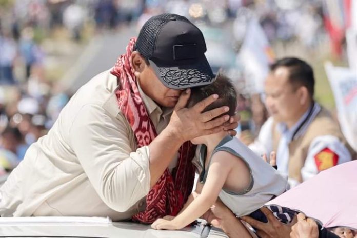 FOTO: Prabowo saat mencium seorang anak kecil yang diarahkan kepadanya saat berada diatas kendaraan miliknya untuk menghadiri kampanye. (Properti Prabowo)