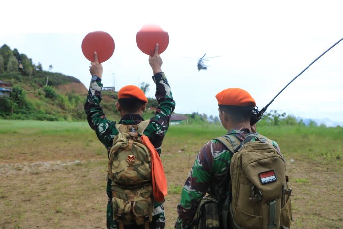 FOTO: Personil TNI AU saat mengarahkan Helikopter Caracal H-225M yang akan mengakut bantuan dan mengevakuasi warga yang terisolir di Kecamatan Latimojong, Luwu, Sulawesi Selatan. (Properti: Lanud Hasanuddin Makassar)