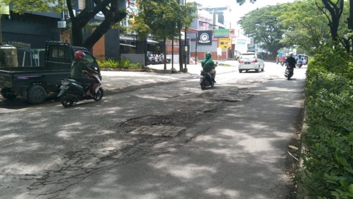 FOTO: Lubang besar di Jalan Hertasning, Kota Makassar. [Properti: Sulselsatu.com]