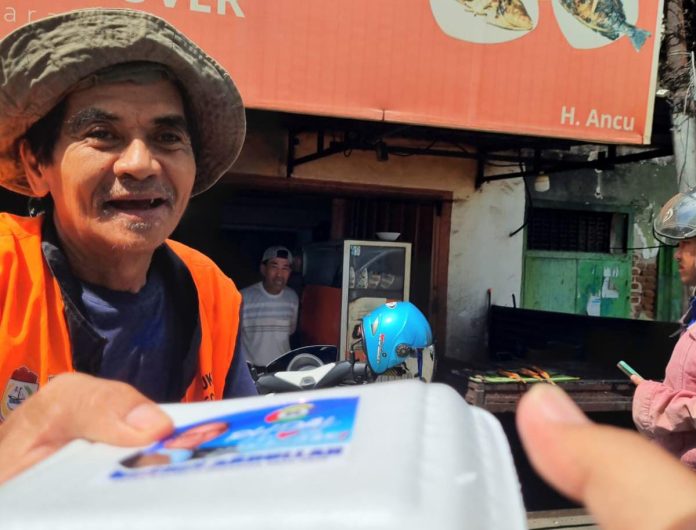 FOTO: Salah satu warga menerima Nasi Kotak dari Tim Sahabat Rudal. Jumat (7/6)