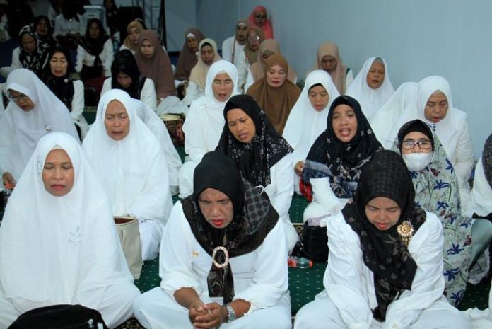 FOTO: Ibu ibu majelis usai salat magrib dan isya menggelar zikir dan doa di posko induk Rudal di Jalan AP Pettarani (Playover) Km. 4 Makassar.