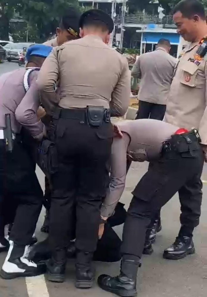 FOTO: Hasil tangkap layar anggota kepolisian pingsan saat pengamanan aksi demontrasi yang digelar Gerakan Mahasiswa dan Pemuda Sulawesi Selatan.