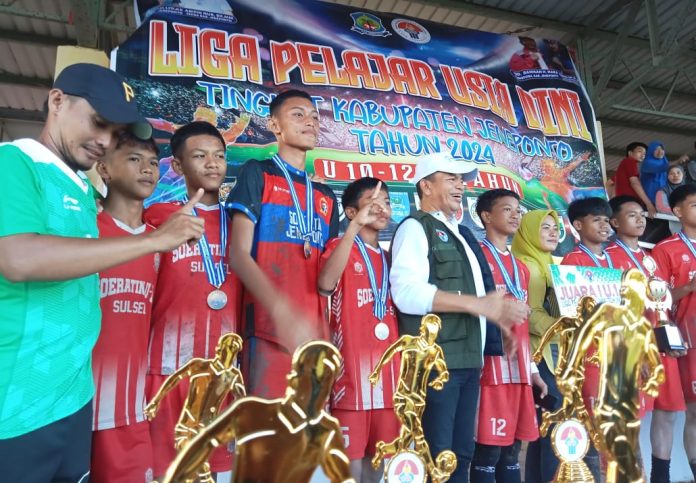 FOTO: Kepala Dinas Pemuda dan Olahraga Kabupaten Jeneponto, Rusman Rukka saat menyerahkan piala dan mendali kepada juara 1 U-14 SSB Turatea.