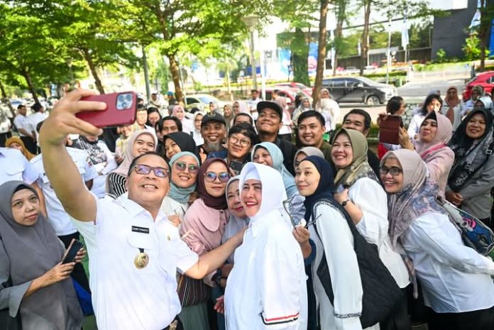 FOTO: Danny Pomanto dan Indira Yusuf Ismail swa foto bersama para ASN di halaman kantor balaikota Makassar. (Properti Danny Pomanto)